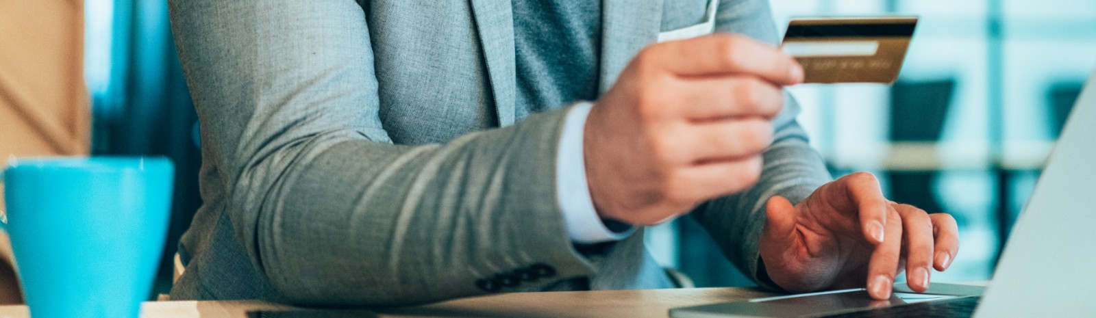 Business professional entering credit card information into laptop