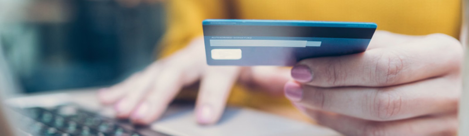 someone using card to purchase something on computer