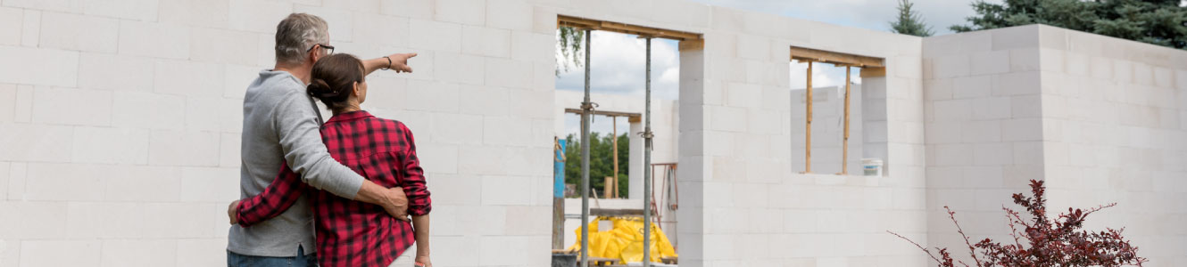 A couple looking at their new home being built