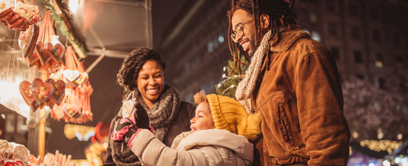 Couple and child in winter coats Christmas Shopping outdoors