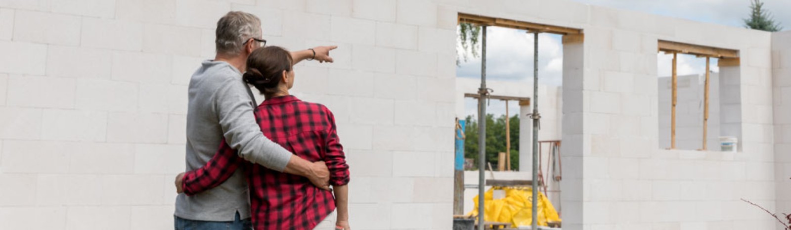 A couple looking at their new home being built