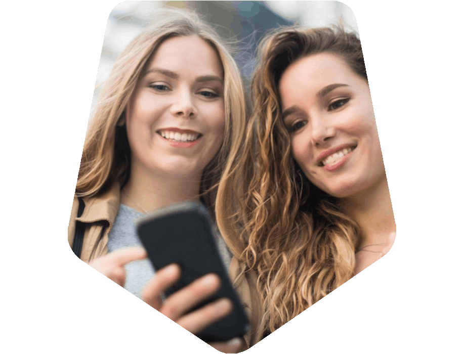 Women in City Looking and Pointing at Mobile Phone
