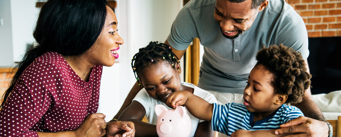 family putting money into piggy bank